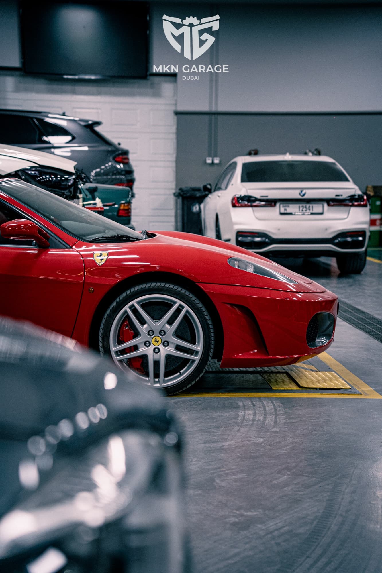 Red Ferrari and white BMW in the MKN garage