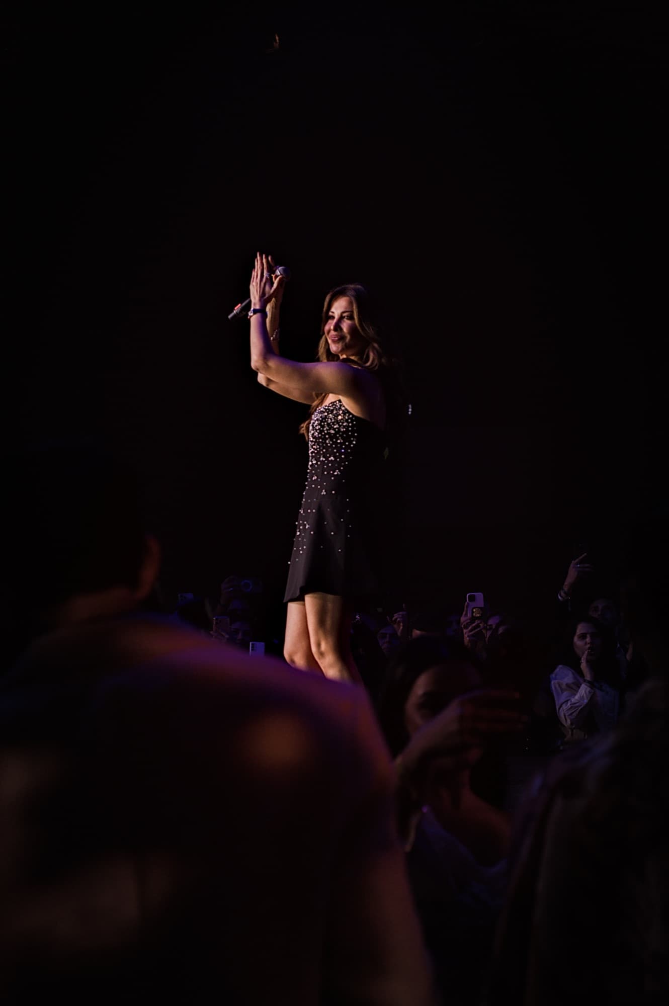 Nancy Ajram performing under a spotlight at Elle Residence