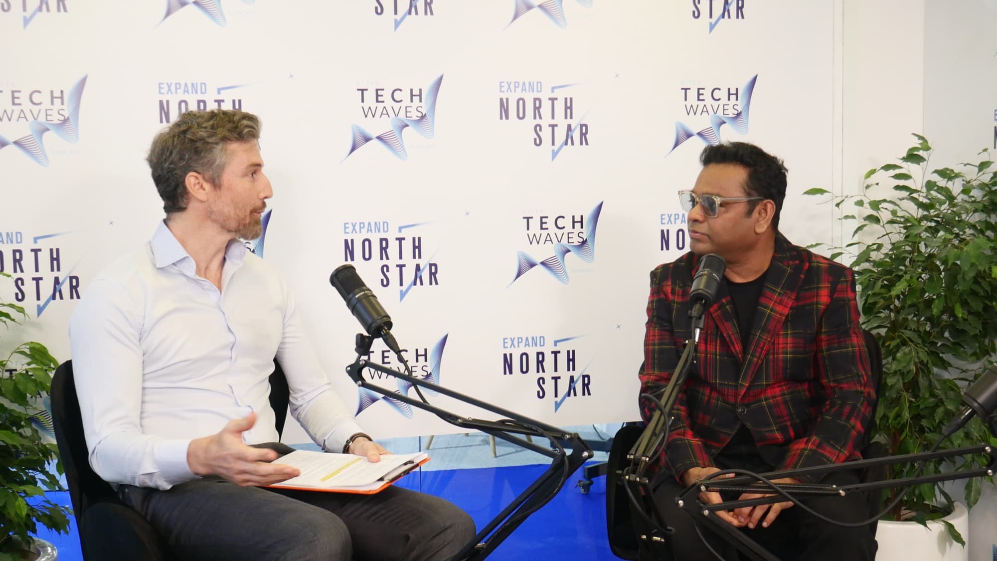 Two speakers mid-interview on a conference stage