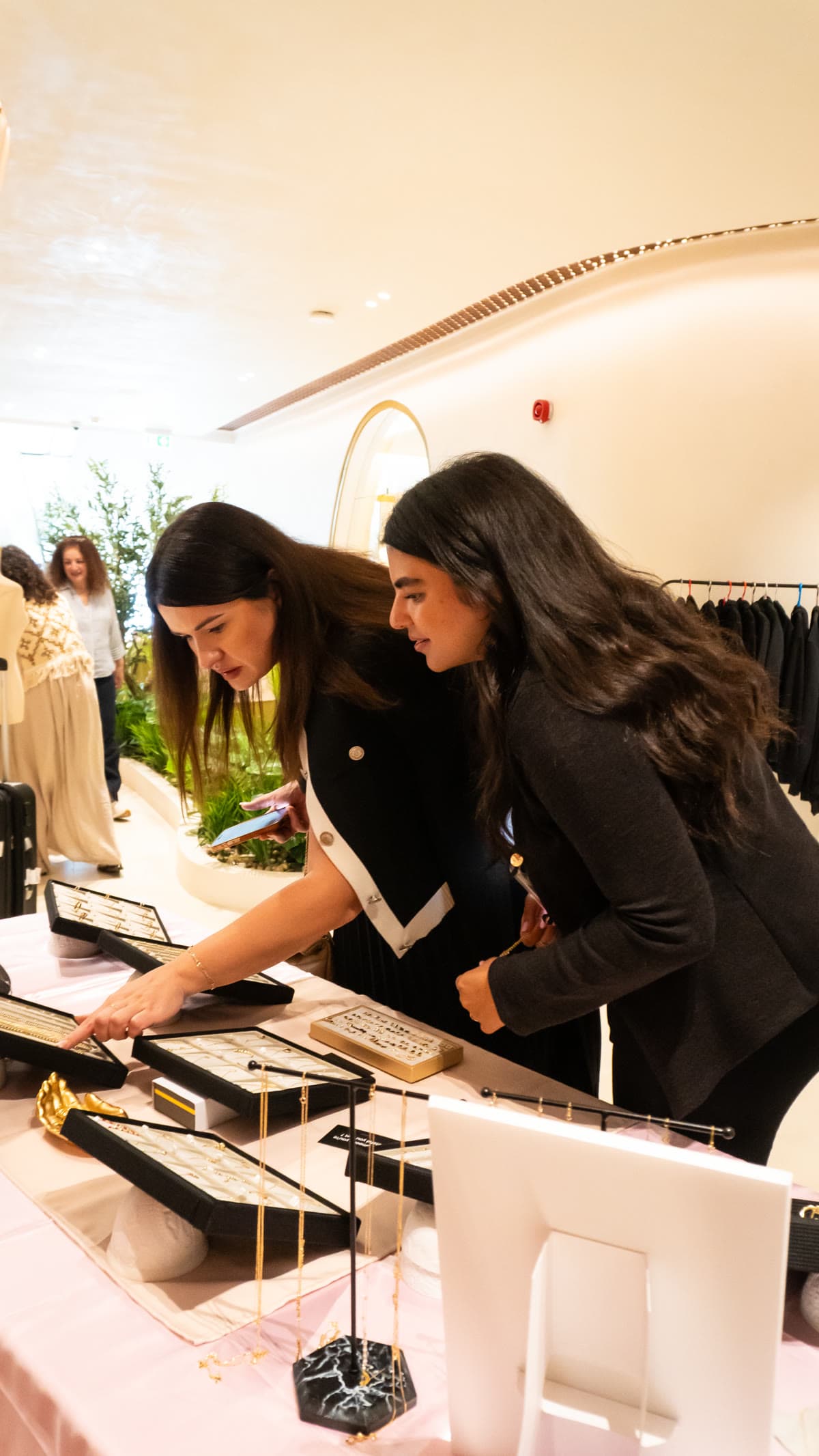 Attendees browsing a jewelry showcase