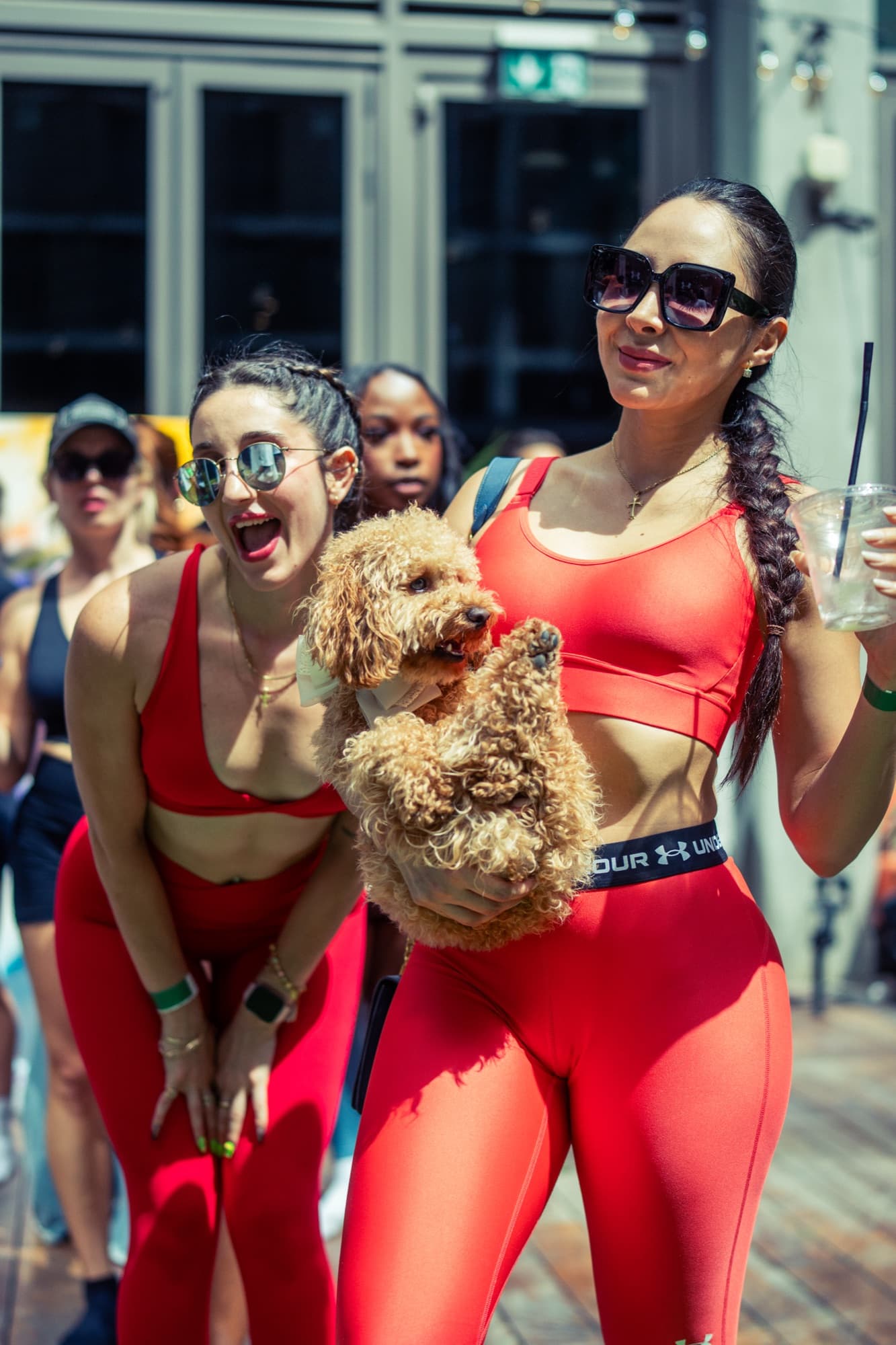 Two guests in red sportswear holding a dog at a Clubhouse event