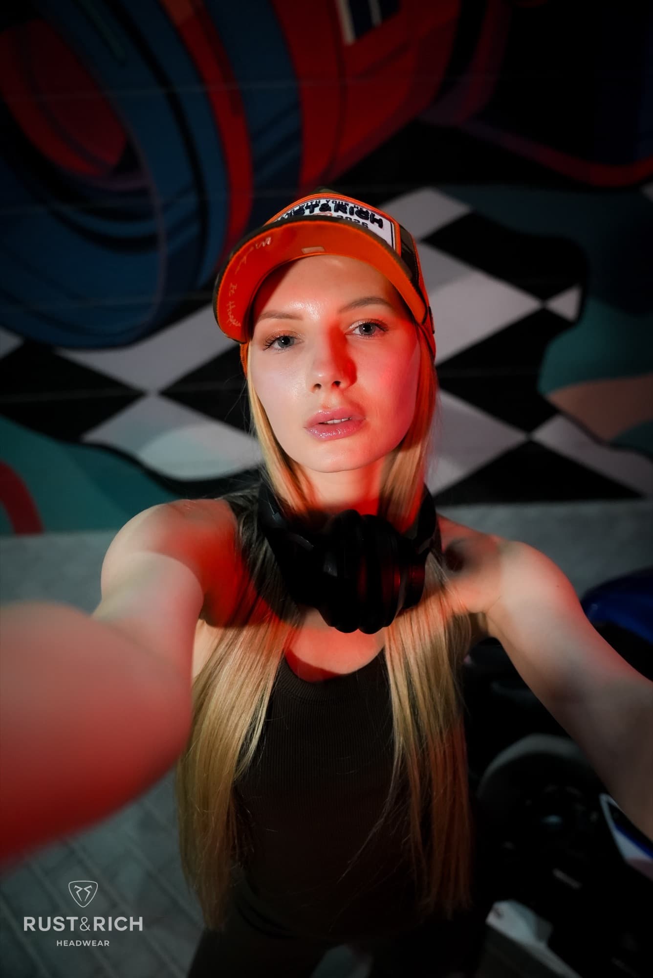 Model in a red branded cap on a checkered set